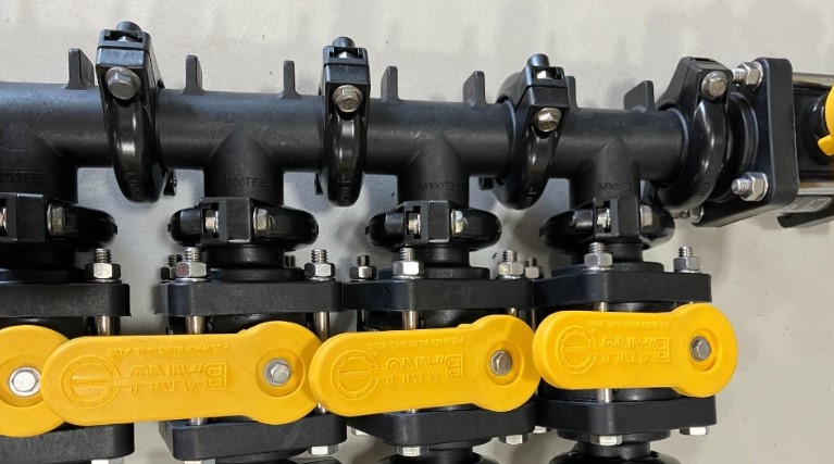 Banjo manifold flange guide clamps used in agricultural systems.